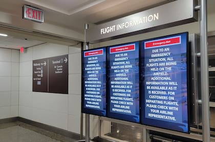 Las pantallas de información en el Aeropuerto Nacional Reagan muestran instrucciones de emergencia después de que un avión se estrelló en el río Potomac en las afueras de Washington, DC, el 29 de enero de 2025