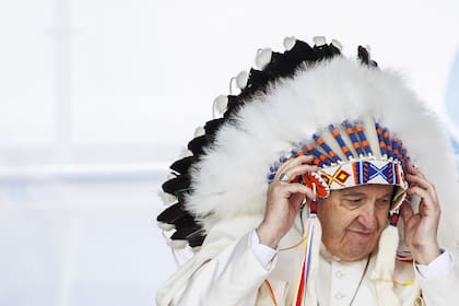 El papa Francisco usa un tocado tradicional que le fue regalado por líderes indígenas durante su visita a Canadá, el 25 de julio de 2022