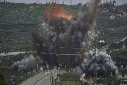 El humo y las llamas se elevan tras un ataque aéreo israelí que impactó el puente Qasmiyeh, cerca de la ciudad costera de Tiro, Líbano, el domingo 22 de marzo de 2026